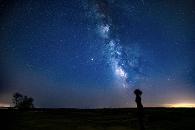 View of woman standing against sky at night