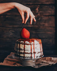 Midsection of person holding ice cream on table