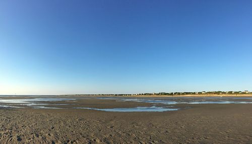 Scenic view of beach against blue sky