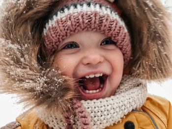 Close-up portrait of a smiling boy in snow