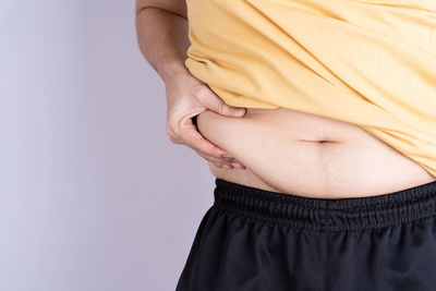 Low section of woman standing against white background