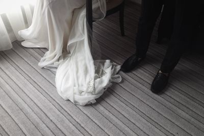 Low section of couple standing on hardwood floor