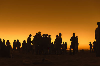 Silhouette people against sky during sunset