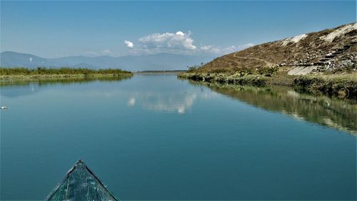 Scenic view of lake by mountains against sky