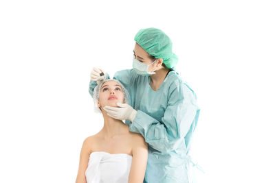 Surgeon with patient against white background