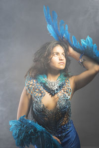 Young woman wearing mask against white background