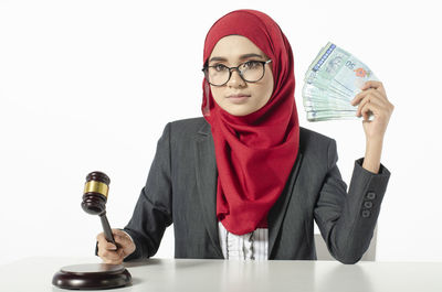 Portrait of young woman with eyeglasses on white background