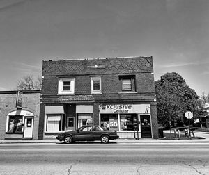 Cars on street by building against sky