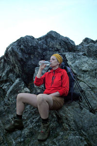 Full length of woman sitting on rock