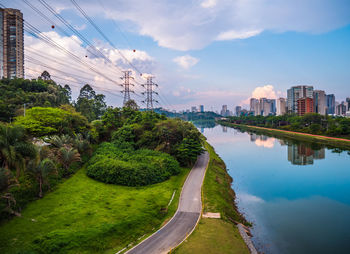 Scenic view of river by buildings against sky