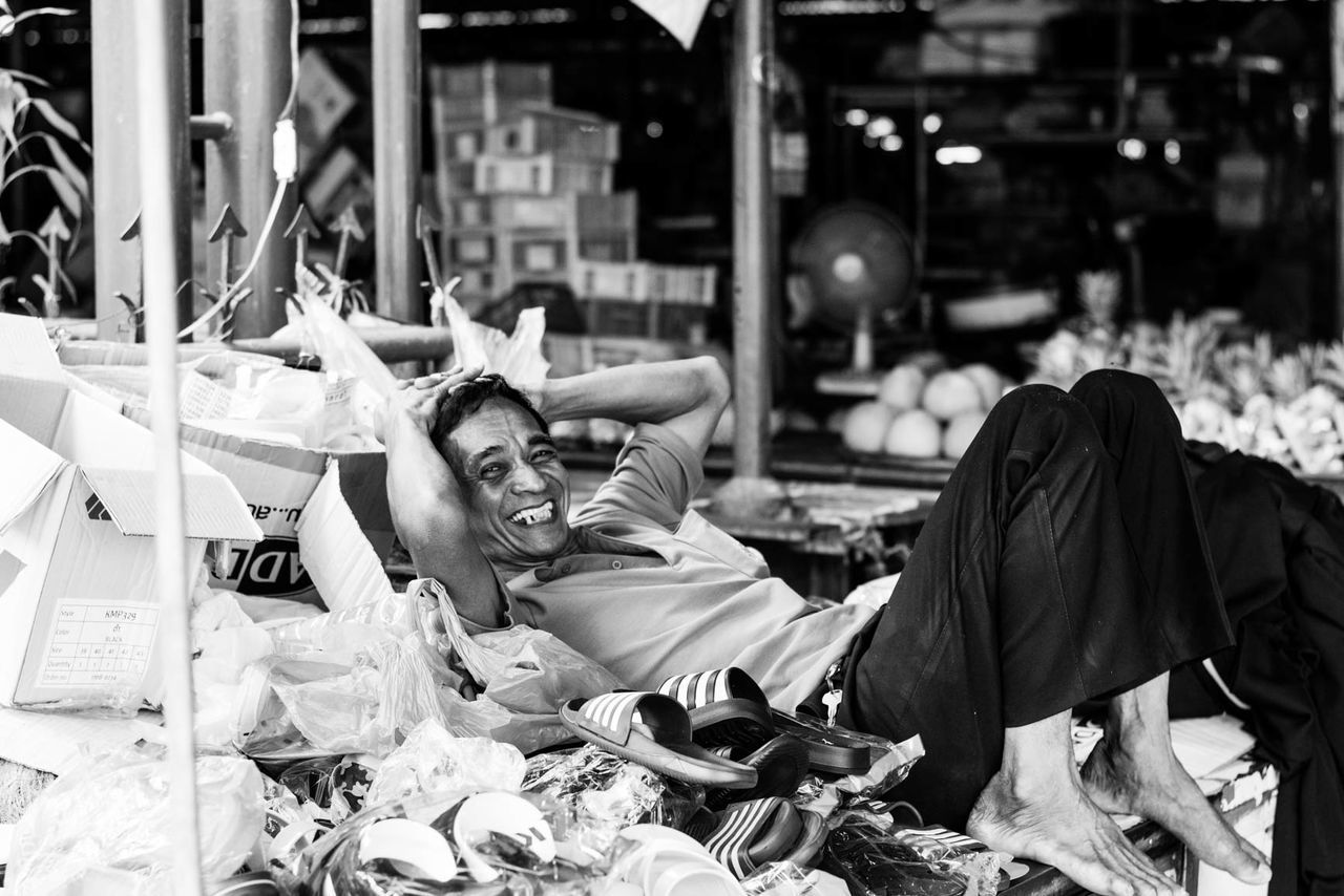 MIDSECTION OF MAN WITH UMBRELLA IN FOREGROUND