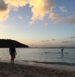 Full length of man on beach against sky during sunset