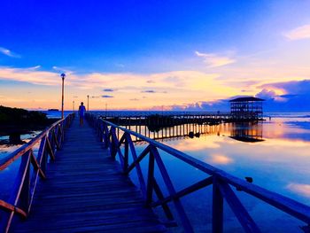 Pier on sea against sky during sunset