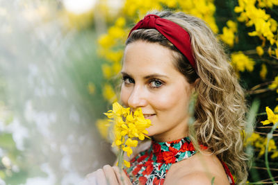 Portrait of smiling woman with yellow flower