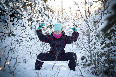 Portrait of boy playing on snow covered land