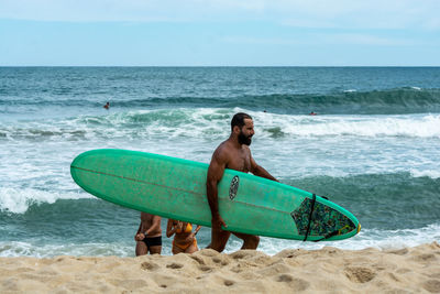 Full length of shirtless man on beach