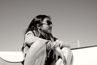 Young woman wearing sunglasses against sky