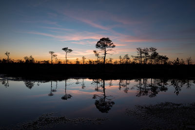 Scenic view of lake against sky at sunset