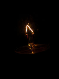 Close-up of lit candle in dark room