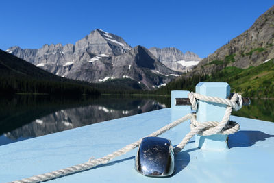 Scenic view of lake and mountains against clear blue sky