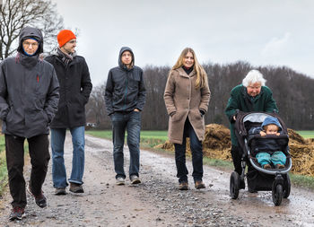 Full length of family wearing warm clothes while walking on footpath during winter