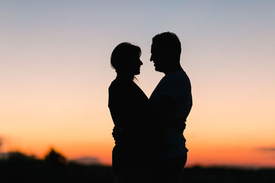 Silhouette of couple kissing at sunset