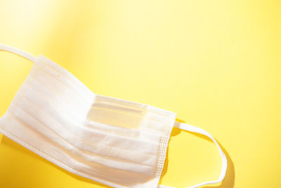 High angle view of eyeglasses on table against yellow background