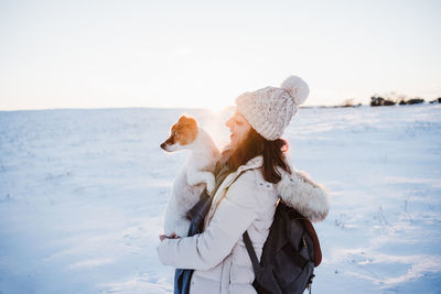 Woman standing on snow against sky during winter