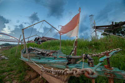 Fishing boat on field against sky