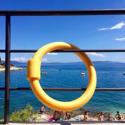 Inflatable ring hanging on railing against sea