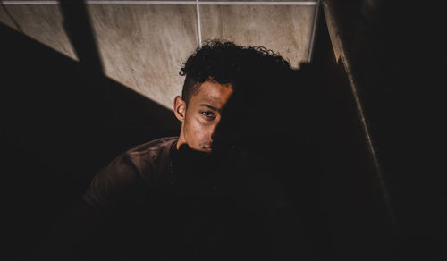 Portrait of young man against black background