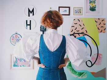 Rear view of woman standing against wall