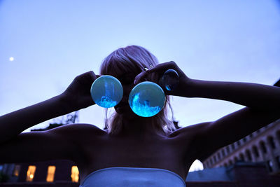 Beautiful woman holding beakers with phosphorescent substance 