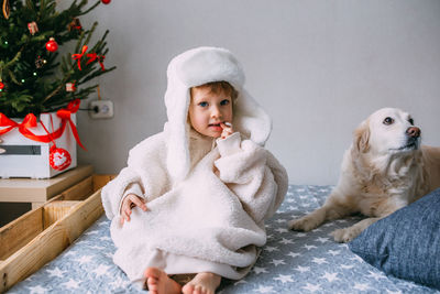 Portrait of cute baby girl lying on bed at home