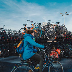 Man riding bicycle on street against blue sky