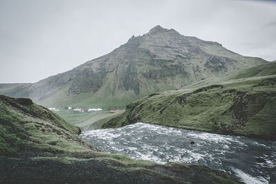 Scenic view of mountains and  skogafoss waterfall 