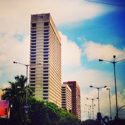 Low angle view of modern building against cloudy sky