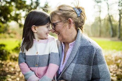 Cute girl smiling at grandma in outdoor setting.