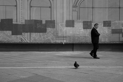 Man walking on footpath in city