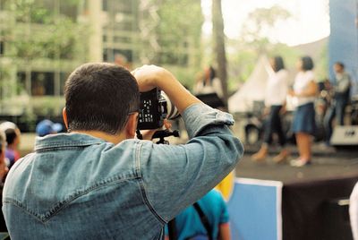 Rear view of photographer photographing performers on stage