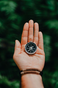 Close-up of hand holding navigational compass outdoors