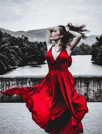 Young woman looking away while standing at sea