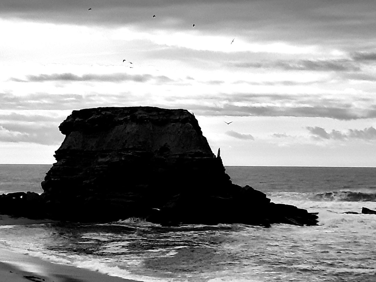 ROCK FORMATIONS ON BEACH AGAINST SKY