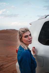 Portrait of woman standing against sky