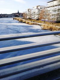 Surface level of frozen river against buildings in city