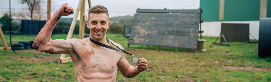 Full length of shirtless man on field