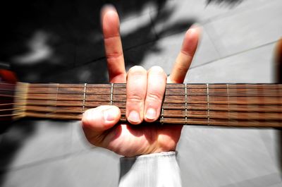 Cropped hand holding guitar outdoors