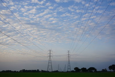 Electricity pylon against sky during sunset