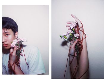 Midsection of woman holding rose against white background