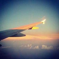 Cropped image of airplane flying against blue sky